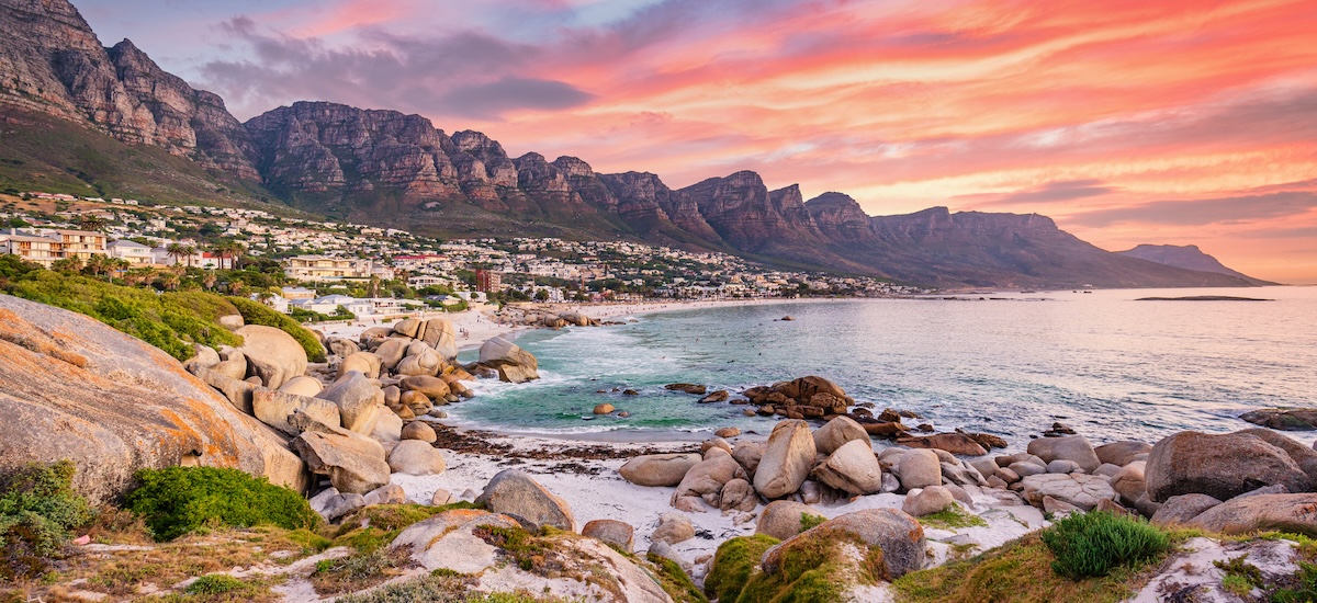 Camps Bay au crépuscule, vue panoramique lors d'un coucher de soleil coloré avec un magnifique paysage nuageux.